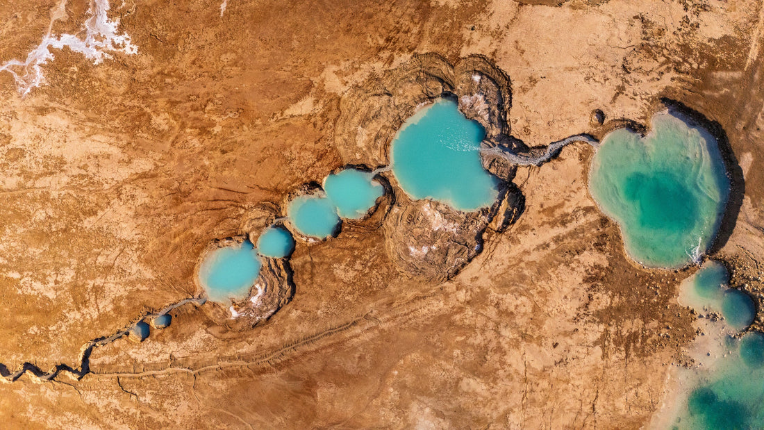 Aerial view of turquoise sinkholes along the Dead Sea shoreline