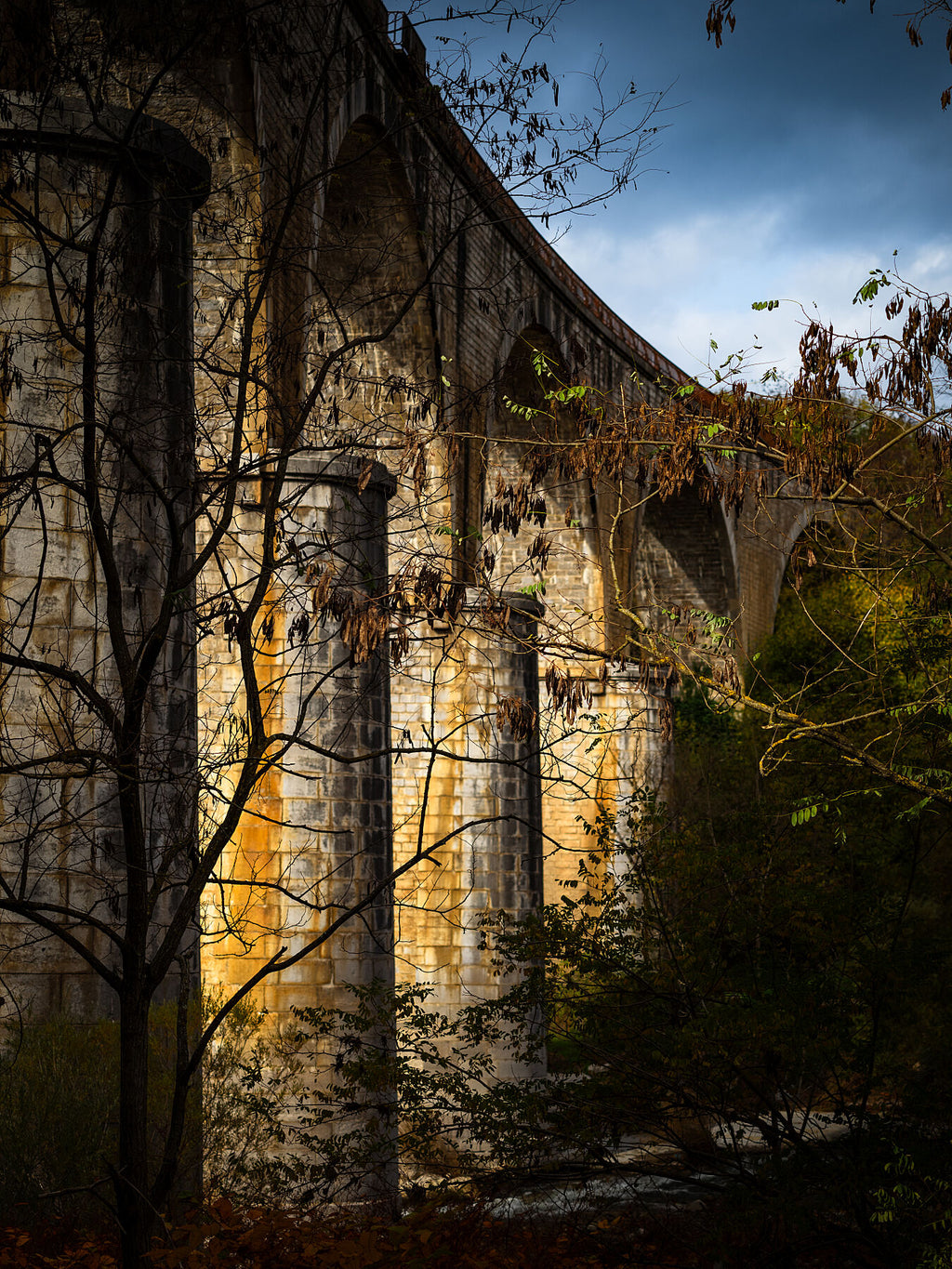 Late sun cutting through an old stone viaduct, fine art print